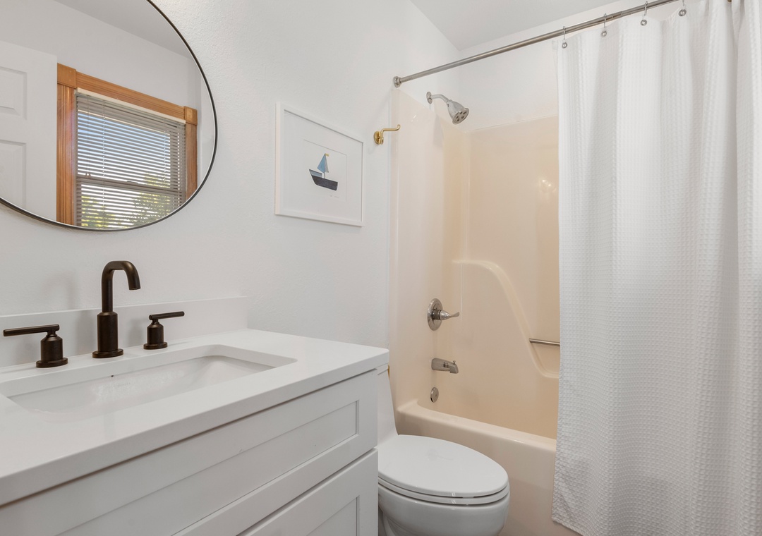 Bathroom with oval mirror and shower-tub