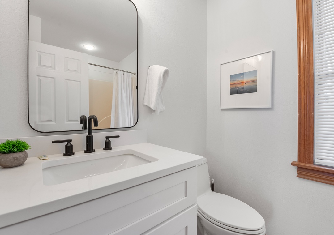 Bathroom with white vanity and sailboat art