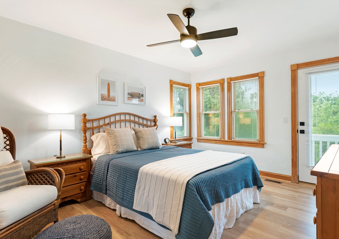 Queen bedroom with blue quilt and corner windows