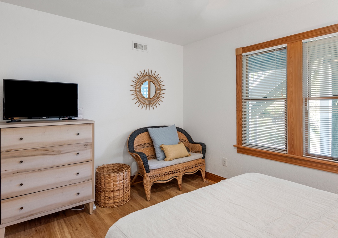 Guest bedroom with light wood dresser and Smart TV
