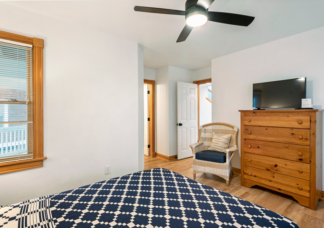 Bedroom with navy quilt and pine dresser