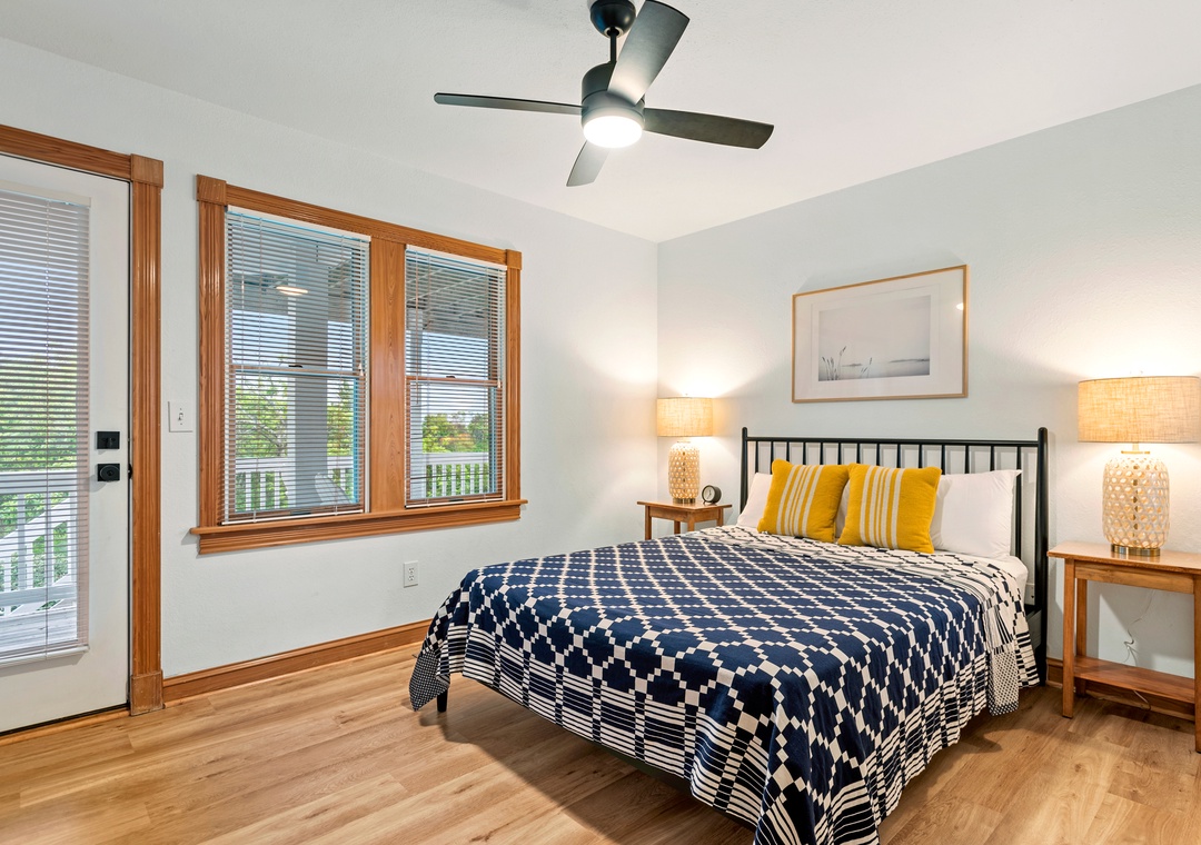 Bedroom with navy quilt, yellow accents and deck access