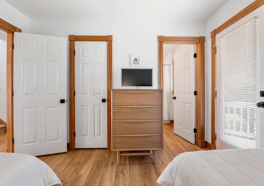 Twin bedroom with light wood dresser
