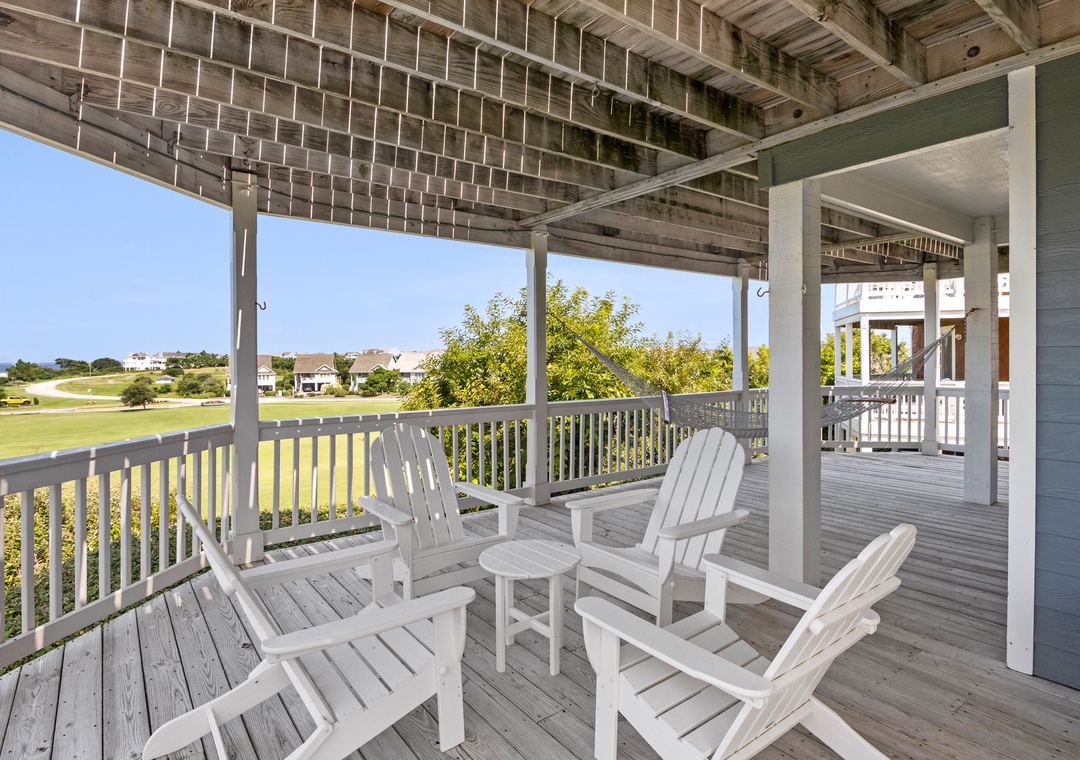 Wraparound deck with Adirondack chairs and golf course view