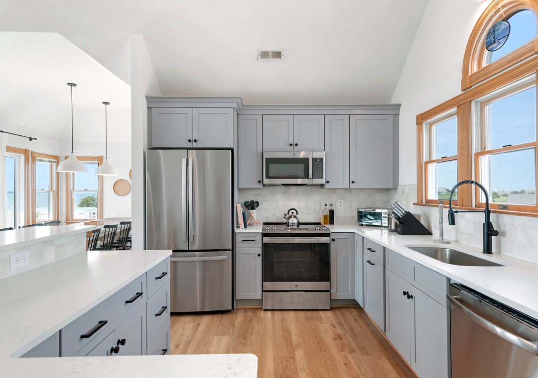 Renovated kitchen with gray cabinets and stainless appliances